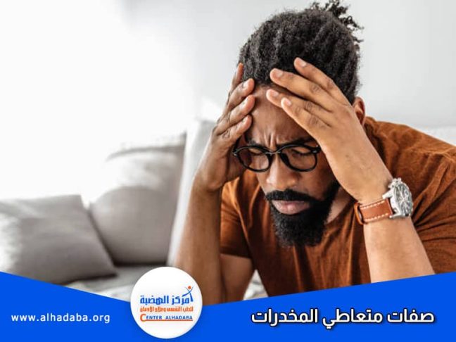 رجل يمسك برأسه ويظهر عليه صفات متعاطي المخدرات